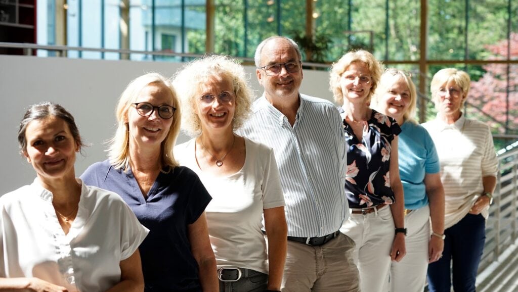 Das Forum Team lehnend am Geländer des Forum Eis